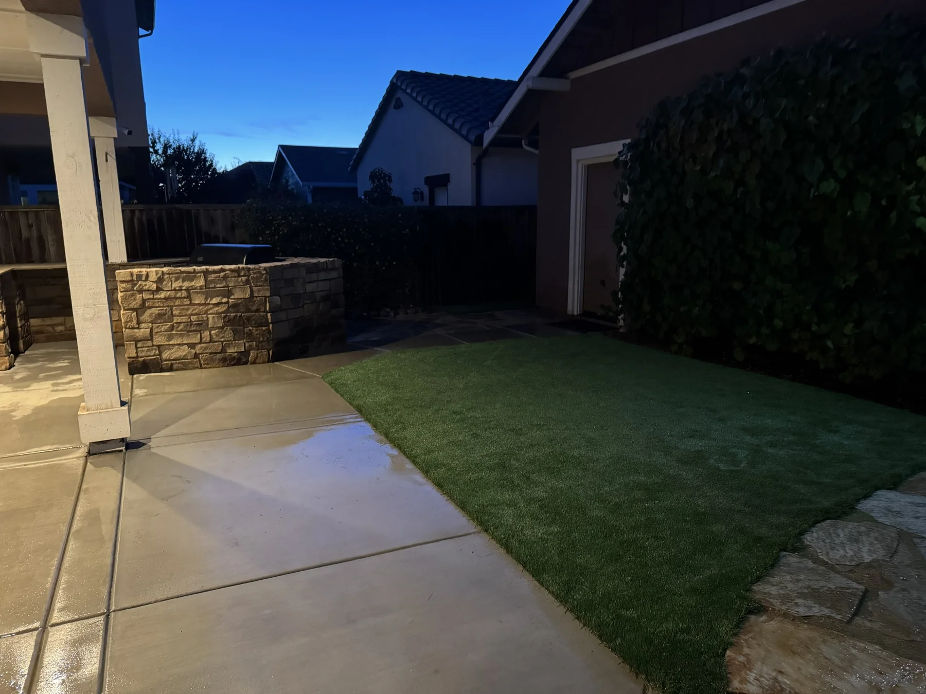 Finished backyard with concrete, artificial turf and masonry