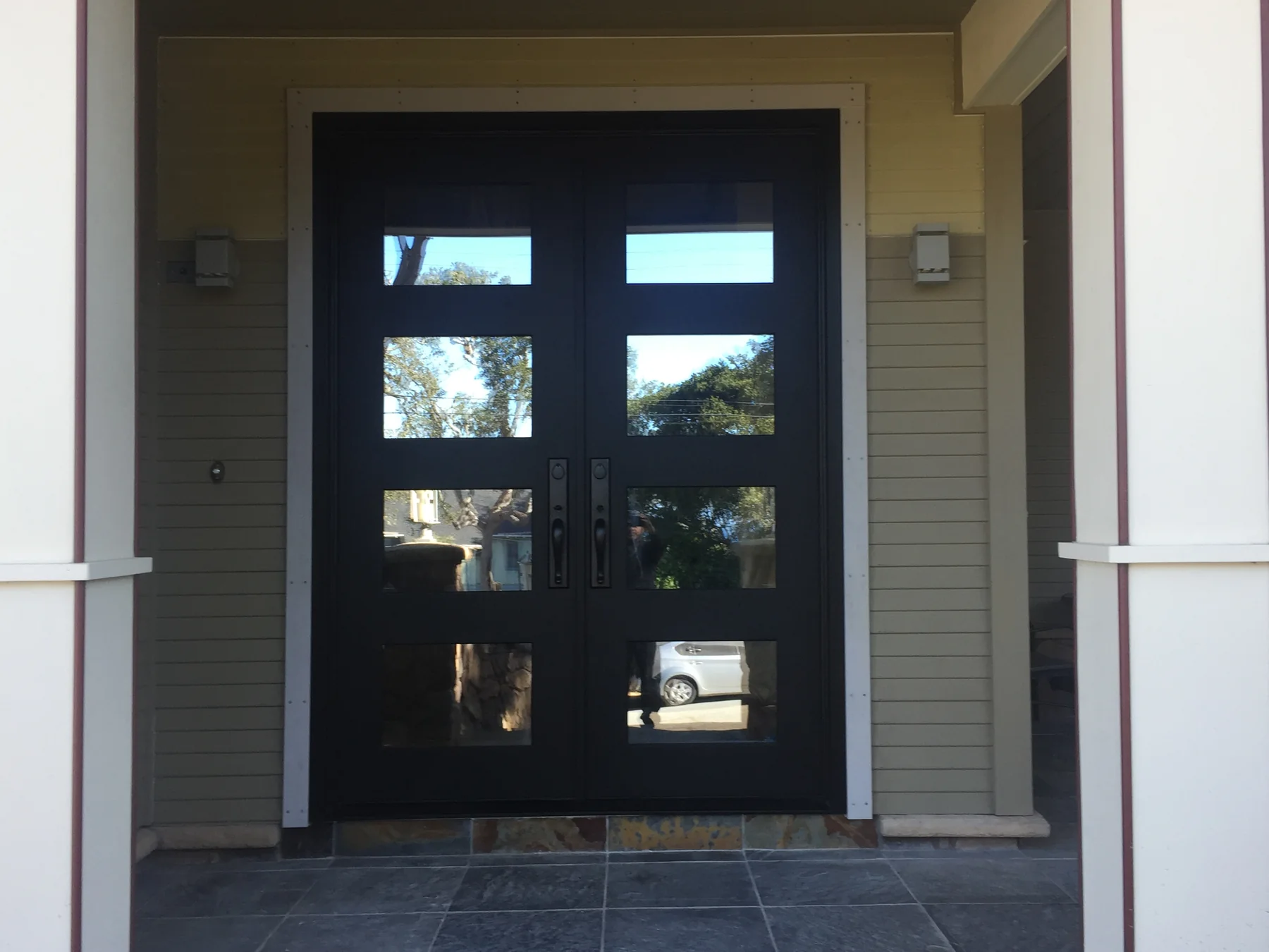 Completed custom residential entry with dark wood doors